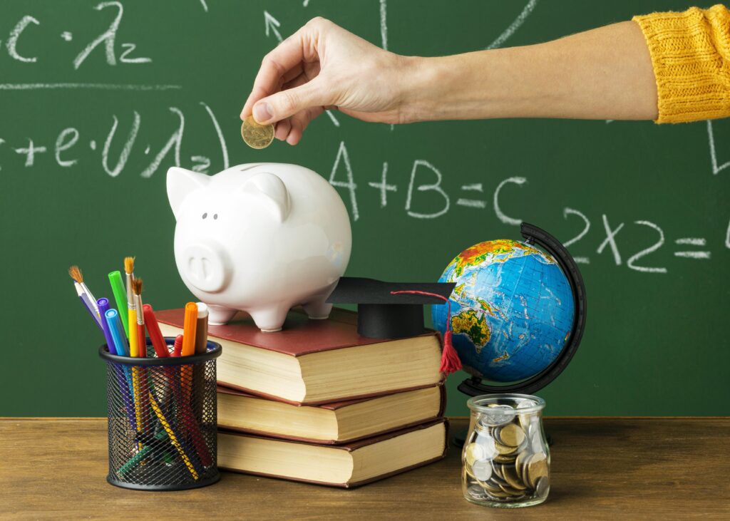 Person putting coins in piggy bank with books and pencils